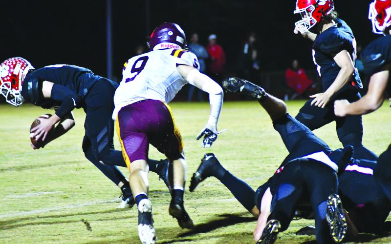 Enoch Autry/The Clayton Tribune. Junior Jarret Giles (far left) scoops up a loose fumble to give the Wildcats good field position in Wolverine territory.