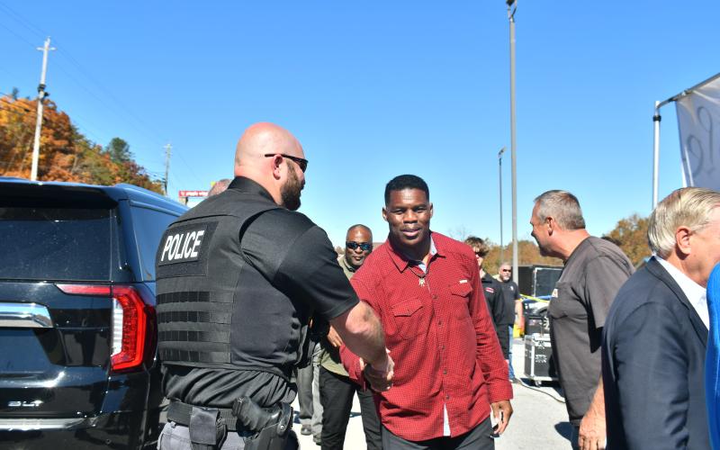 Megan Broome/The Clayton Tribune. Clayton Police Sgt. William Wall shakes the hand of U.S. Senate candidate Herschel Walker at his Oct. 26 rally.