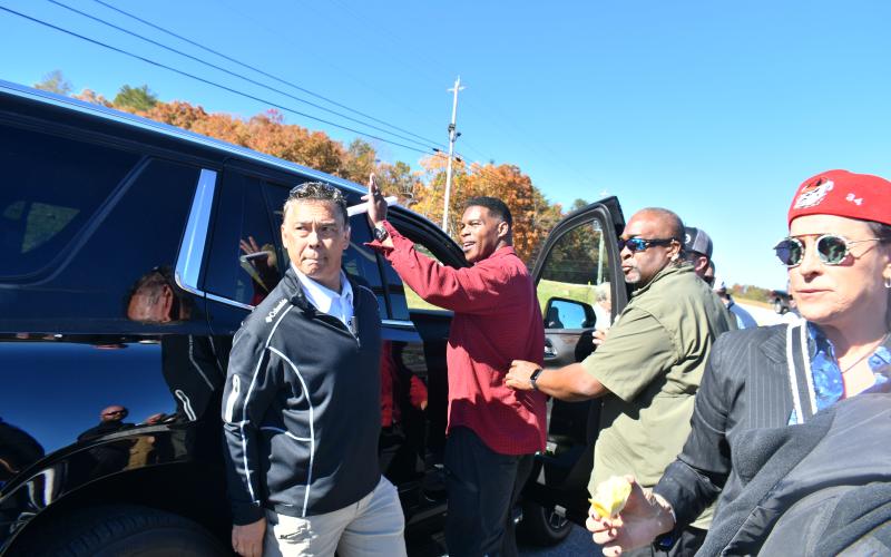 Megan Broome/The Clayton Tribune. Herschel Walker waves to crowds of people as he leaves the Piggly Wiggly parking lot in Dillard following a rally Oct. 26.