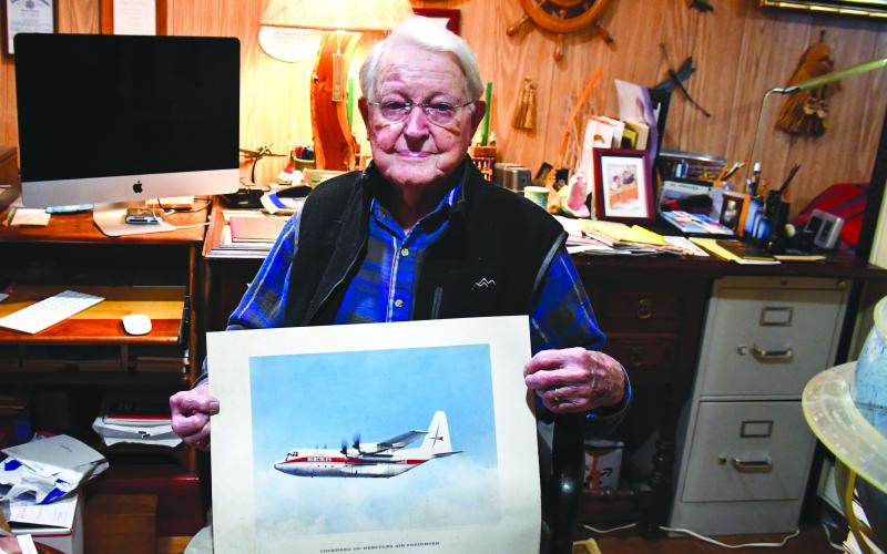 Megan Broome/The Clayton Tribune. Pilot and WWII Army veteran Capt. Douglas Day spends time in his Captain’s Quarters, among memorabilia from his lifetime of world travels as a pilot. Replicas of planes he once flew hang from the ceiling among globes, books, a map with pins of his world destinations, and other artifacts. Day also continues wood working.