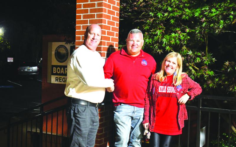 Megan Broome/The Clayton Tribune. Candidates for Magistrate Judge James Blalock and Kyle Shook shake hands outside the Rabun County Board of Elections Office Tuesday evening as they await election results. Also pictured is Sonya Shook.
