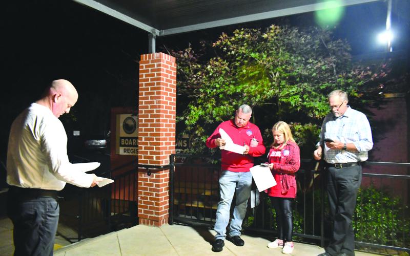 Megan Broome/The Clayton Tribune. James Blalock, candidate for Magistrate Judge, Kyle Shook, write-in candidate for Magistrate Judge, Sonya Shook and John Bradshaw look over election results as they come into the Rabun County Board of Elections Office Tuesday evening.