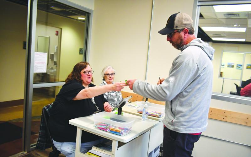 Megan Broome/The Clayton Tribune. Voter Greg Malnar verifies his information with poll workers Amanda Burrell, left, and Ann D’Agostino before casting his ballot on Election Day Tuesday at the Rabun County Board of Elections Office.