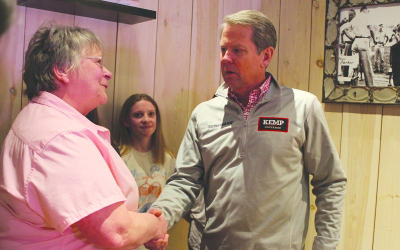 Megan Broome/The Clayton Tribune. Bonnie Edmonds of the Clayton Cafe shakes the hand of Gov. Brian Kemp during his campaign stop to Clayton in February.