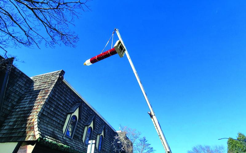 Photo courtesy of Trudy Crunkleton. The iconic Christmas candle located in downtown Clayton was brought back as a decoration after 35 years. Pictured is the candle being suspended to be placed near Reeves on Main Street.