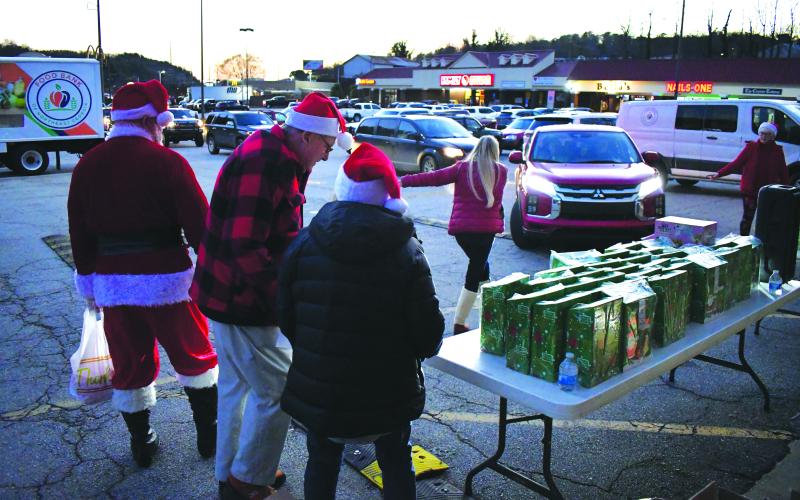 Enoch Autry/The Clayton Tribune. Childen came in vehicles to the Food Bank of Northeast Georgia on Dec. 16 for a drive-thru Christmas gift giveaway. The youth saw Santa Claus as he greeted families at 46 Plaza Way in Clayton.