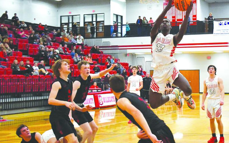 Luke Morey/The Clayton Tribune. With teammates junior Cooper Welch (14) and senior Jayton Henry (20) in the background, junior Willie Goodwyn goes up for a layup in the fourth quarter of Saturday’s game against Franklin, N.C. Goodwyn scored 12 points to help the Wildcats to a narrow 43-40 victory.