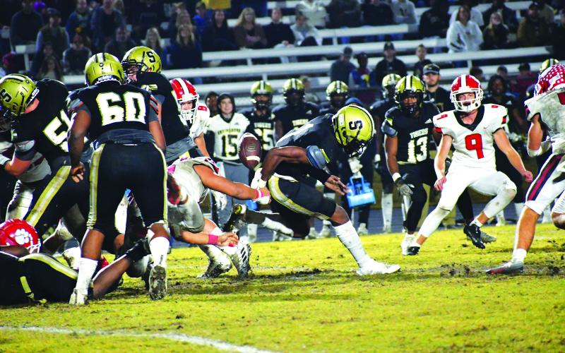 Luke Morey/The Clayton Tribune. RCHS senior Cesar Cruz strips the ball from Damello Jones in the third quarter as seniors Noah Legault (4), Cory Keller and junior Jarret Giles (9) look on. Cruz ended the season with 60 total tackles, two sacks and two forced fumbles.