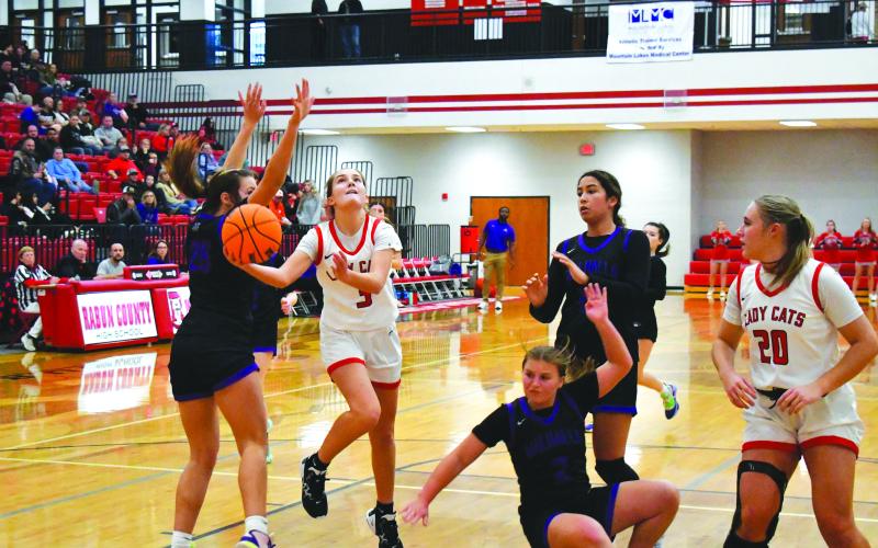 Luke Morey/The Clayton Tribune. With junior Ellie Southards looking on, senior Trea Blalock hits a layup against Walhalla on Friday, Dec. 16. A consistent starter for the Lady Cats, Blalock scored nine points and seven boards on the night.
