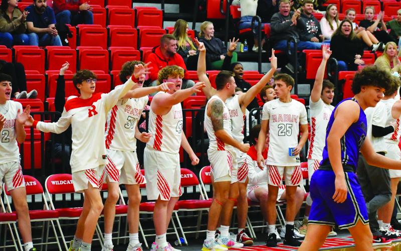 Luke Morey/The Clayton Tribune. Wildcats on the bench and in the stands celebrate Henry’s game-sealing three against Walhalla. Pictured on the bench include from left, Michael Bone, Hayes Free, Mike Swager, Noah Legault, Evans Palmer and Tristan Burrell.