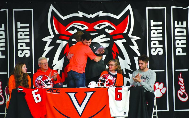 Luke Morey/The Clayton Tribune. Jaden Gibson hugs Wes Holcombe during the ceremony. Holcombe was the passing coordinator for Rabun County and has worked with Gibson for the past two years.