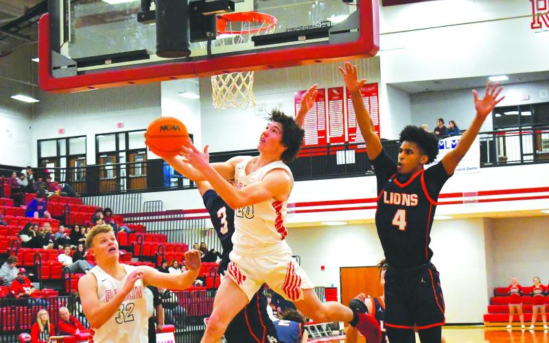 Luke Morey/The Clayton Tribune. Junior Jack Hood (32) watches as senior Jayton Henry hits a tough reverse layup against two  Lakeview defenders on Wednesday, Dec. 21.