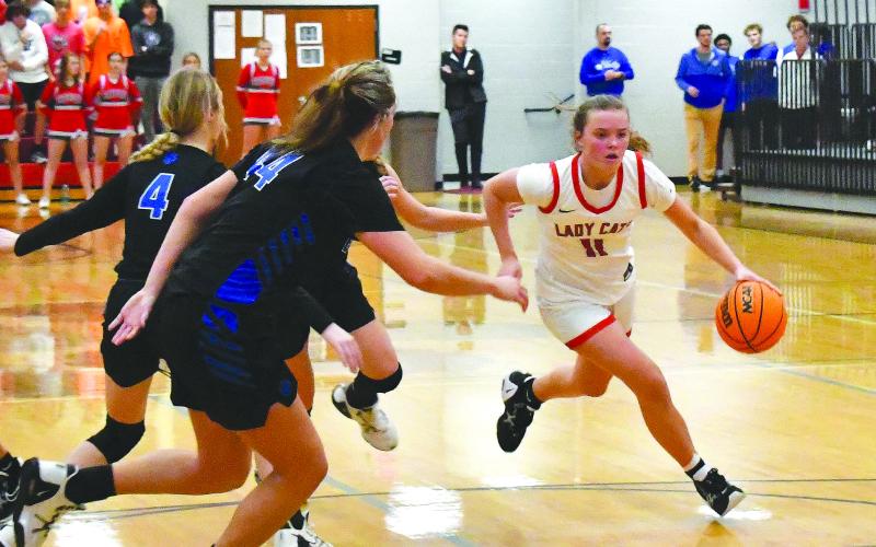 Luke Morey/The Clayton Tribune. RCHS junior point guard Lucy Hood drives against three Banks County defenders on Friday night. Hood ended with 15 points on the night. She has been leading the team in points averaging around 17.5 points per game on top of being the primary ball handler for RCHS, averaging around five assists per game.