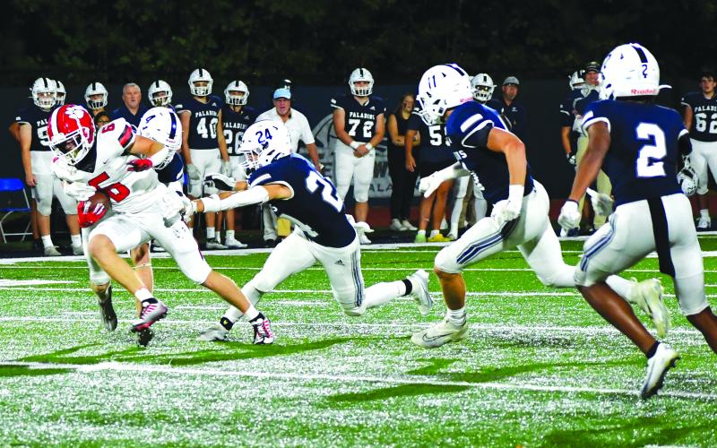 Luke Morey/The Clayton Tribune. Gibson breaks through two arm tackles against Fellowship Christian.