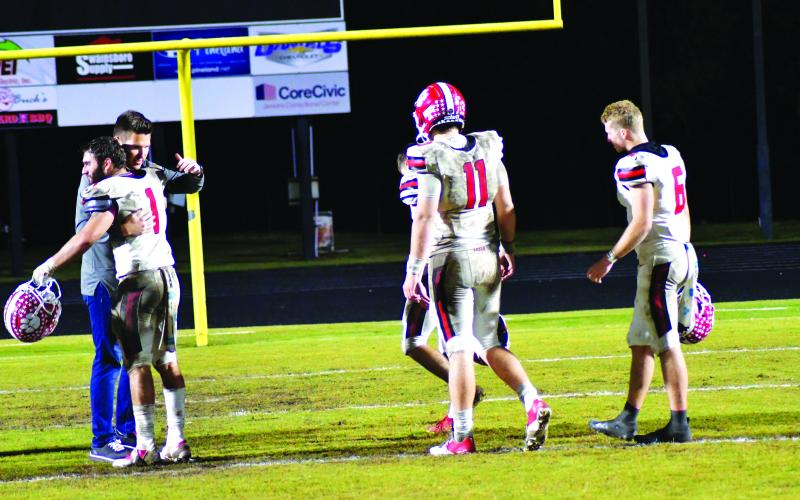 Enoch Autry/The Clayton Tribune. Rabun County High School Principal Justin Spillers gives Nic Baloga a hug as fellow seniors Lang Windham, Keegan Stover, and Jaden Gibson walk off the field in Swainsboro following the Wildcats’ 35-10 Nov. 25 Class A Division I state quarterfinal loss to the Tigers. Each of these seniors were statewide leaders in various individual categories.