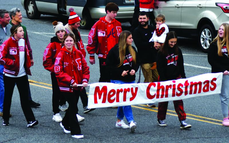 Enoch Autry/The Clayton Tribune.  Student-athletes from the Rabun County High School softball team carry the “Merry Christmas” banner near the beginning of the Dec. 3 Clayton Christmas Parade on Main Street.