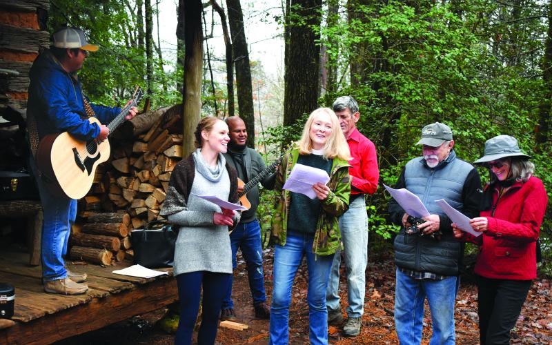 Enoch Autry/The Clayton Tribune. The choir from St. Helena’s Catholic Church perform Christmas carols. The choir members (from left) are musician Andres Santiago, Foxfire Assistant Curator Kami Ahrens, musician Eduardo Castro, and vocalists Chantal Gourlay, Andrew Timan, Stephan DeBlasio, and Luann Luedtke.