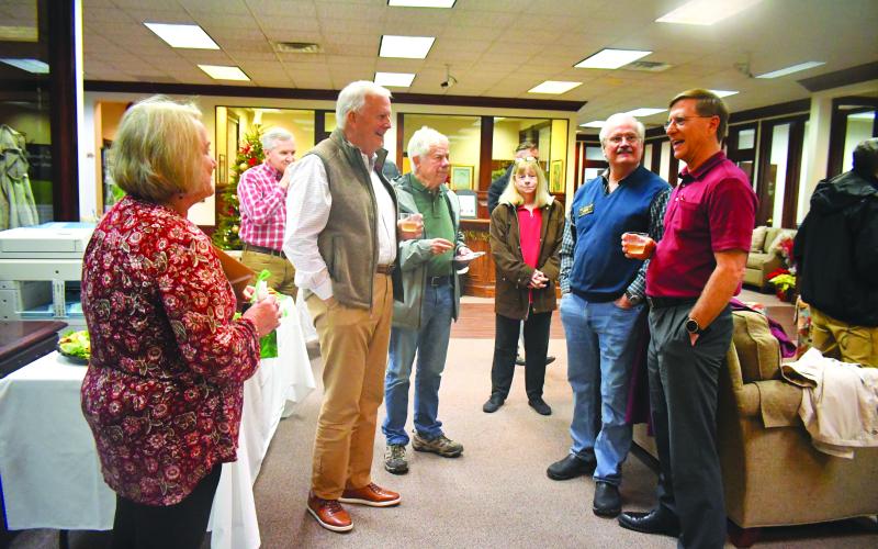 Megan Broome/The Clayton Tribune. Greg Funkhouser (right) and wife Cathee smile and laugh as they meet-and-greet community members at Rabun County Bank Dec. 14 for a retirement reception honoring his 43 years of service at the bank.