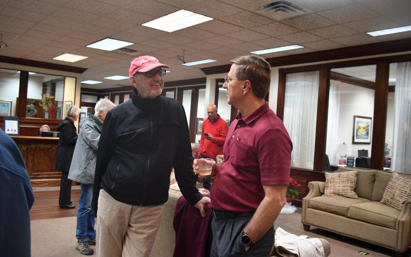 Megan Broome/The Clayton Tribune. Greg Funkhouser (right) talks with Dr. Guy Gober at Funkhouser's retirement reception held at Rabun County Bank Dec. 14.