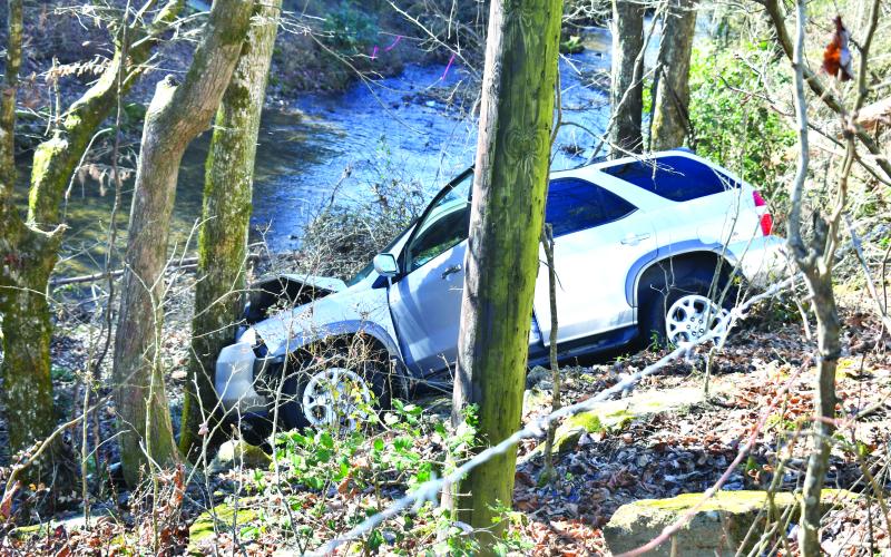 Megan Broome/The Clayton Tribune. This white 2001 Acura MDX struck a wire cattle fence and then a tree after traveling down an embankment during a single vehicle crash on Highway 76 West near Olas Lane in Clayton Nov. 28. Minor injuries were reported.