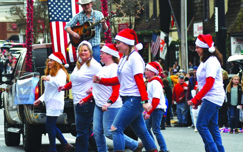 Enoch Autry/The Clayton Tribune. For the Mountain City Playhouse float with Jake McCrackin playing his guitar, Veronica Dono, Sharon Williams, Jennifer Miller, Courtney Jarriel, Christopher Woodall and Samantha Joedicke line dance to the music for the judges near The Rock House on North Main Street in Clayton.