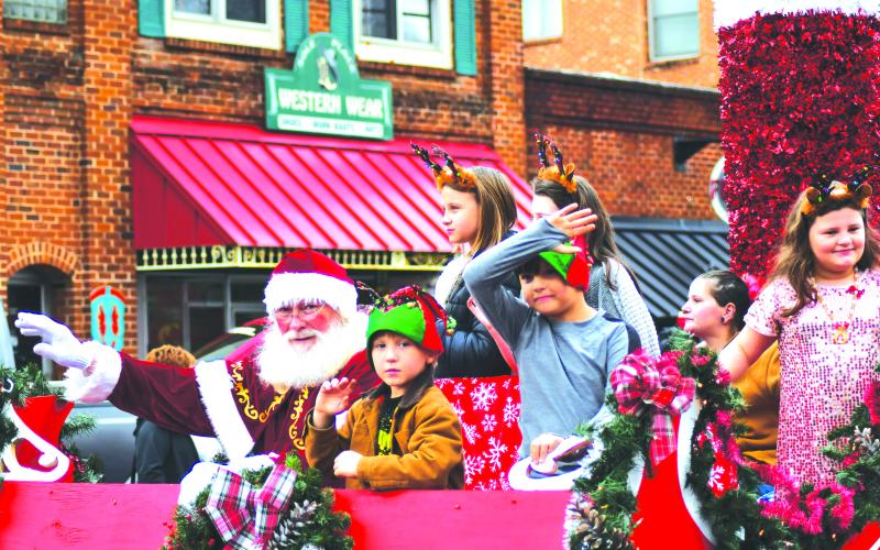 Enoch Autry/The Clayton Tribune. Santa Claus and youth on the City of Clayton’s float wave to the crowd at the Dec. 3 Clayton Christmas Parade near The Rock House on Main Street.
