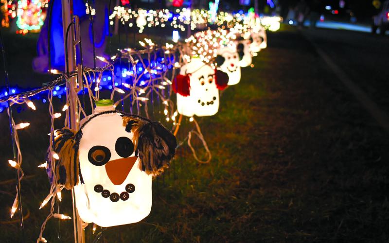 Megan Broome/The Clayton Tribune. These snowmen made out of milk bottles are some of many decorations to see at the Christmas Village of Lights display in Tiger during the holiday season.