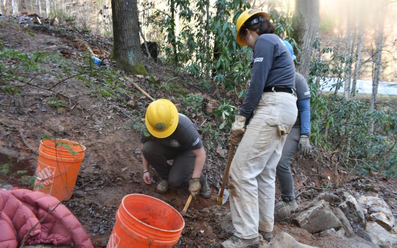 Megan Broome/The Clayton Tribune. Crew members with the Southeast Conservation Corps work together to carry large and heavy stones to a portion of the Bartram Trail at Warwoman Dell in order to build a set of stone stairs on the popular and highly-used trail.