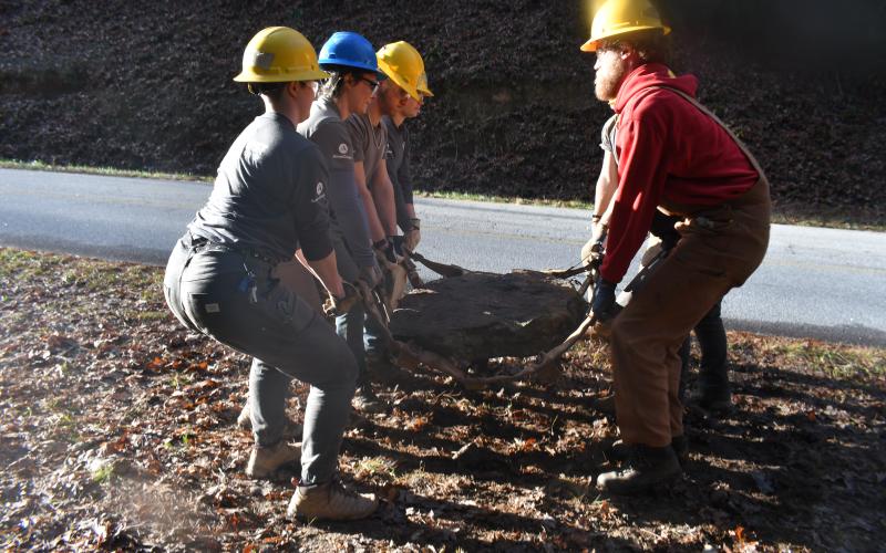 Megan Broome/The Clayton Tribune. Crew members with the Southeast Conservation Corps work together to carry large and heavy stones to a portion of the Bartram Trail at Warwoman Dell in order to build a set of stone stairs on the popular and highly-used trail.