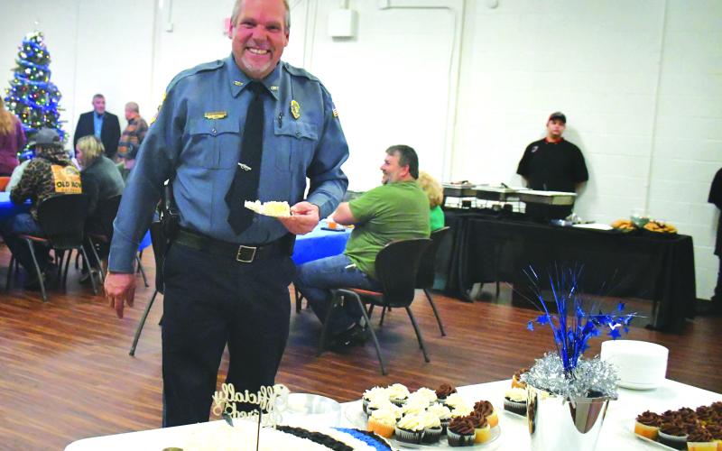 Megan Broome/The Clayton Tribune. Mountain City Police Chief Tom Garrison is all smiles as he cuts his cake at his retirement reception from the City of Mountain City on Dec. 30, 2022. Garrison retires after serving as a law enforcement officer for 28 years and Mountain City Police Chief for 18 years.