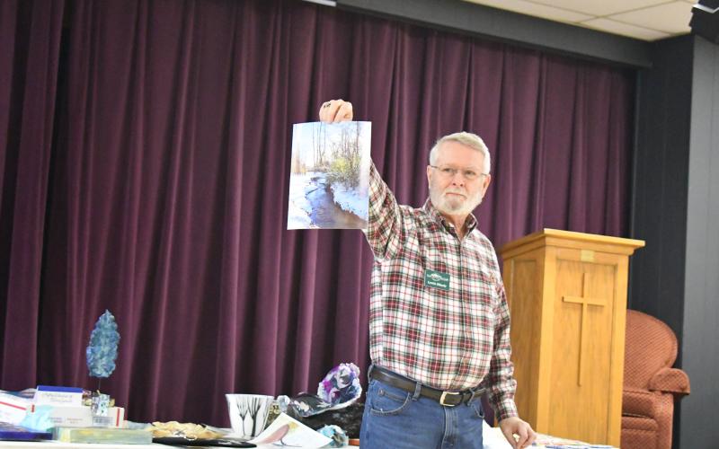 Megan Broome/The Clayton Tribune.  North Georgia Arts Guild member Lewis Hinely shows his artwork at the Members' Show and Tell event titled "Winter Blues."
