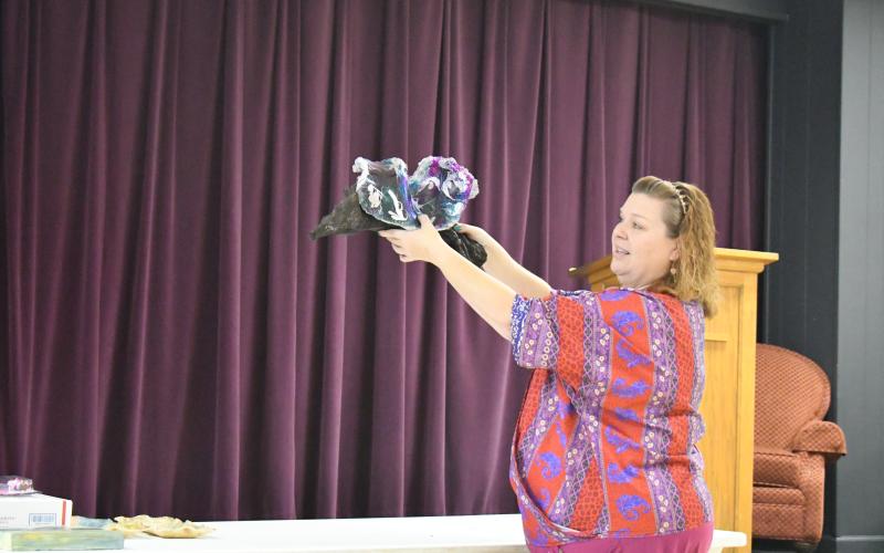 Megan Broome/The Clayton Tribune. North Georgia Arts Guild member Nicole Tomaszewski holds up a piece of artwork she created that was inspired by her kayaking trips with her husband.