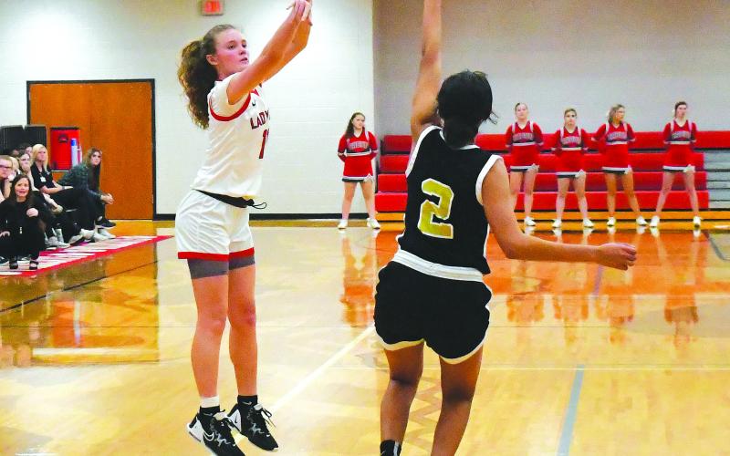 Luke Morey/The Clayton Tribune. RCHS junior Lucy Hood  hits a three pointer on Tuesday, Feb. 21. Hood ended with 25 points, good enough to push her over 1,000 points in her career. Hood helped lead the Lady Cats to a 74-57 victory. The Lady Cats are waiting for their Sweet Sixteen opponent to be announced.