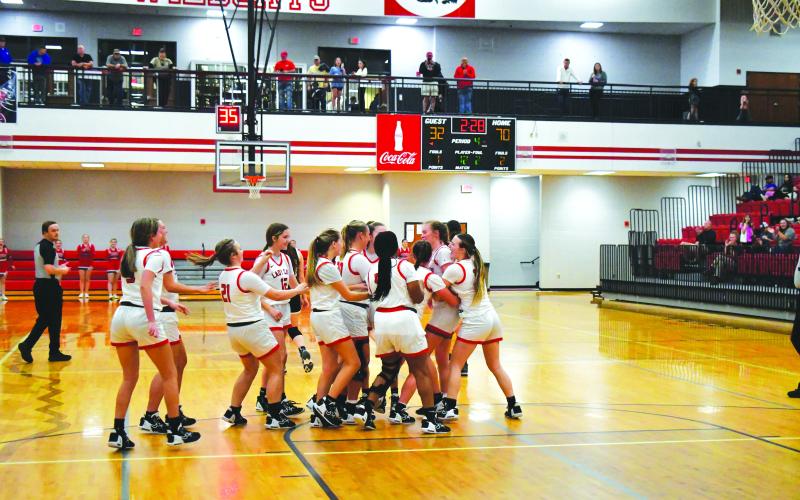 Luke Morey/The Clayton Tribune. RCHS junior Luc y Hood gets surrounded by her teammates after hitting two free throws to reach 1,000 career points. Hood ended with 25 points and was awarded a game ball for her 1,000 points.