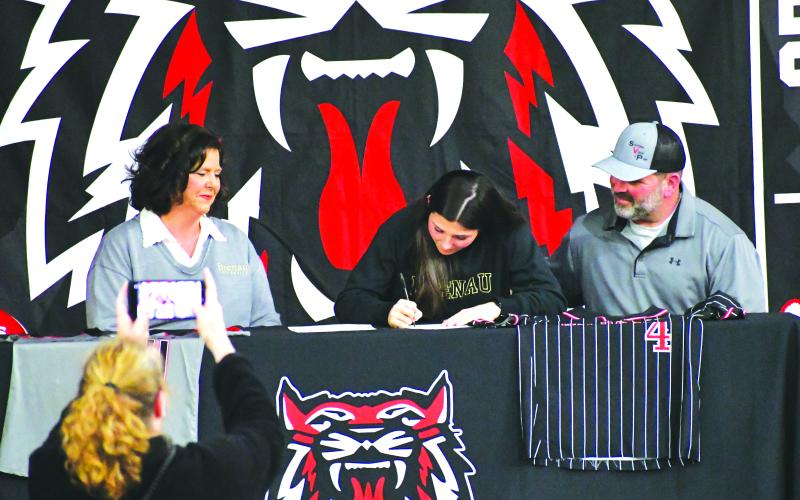 Luke Morey/The Clayton Tribune. Surrounded by parents Kim and Christian Lovell, Rabun County senior Mary Lovell signs her Letter of Intent on Tuesday, Jan. 31. Lovell, who has played softball and basketball at RCHS, will attend Brenau University for softball. In her senior softball season, Lovell hit .451 with five home runs for the Lady Cats.