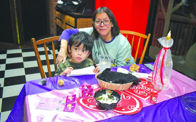 Megan Broome/The Clayton Tribune. Place of Hope North Georgia Volunteer Amelia Miller along with Quinten Racadag, 4, show their support.