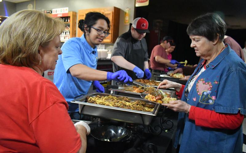Megan Broome/The Clayton Tribune. Terry Wright, right, is served pasta by Brenda Bowen, of The Soda Fountain Restaurant and Catering, and Place of Hope Volunteer Ira Racadag, at the restaurant’s Valentine’s Day Italian Buffet event which raised money for the local nonprofit Place of Hope North Georgia.