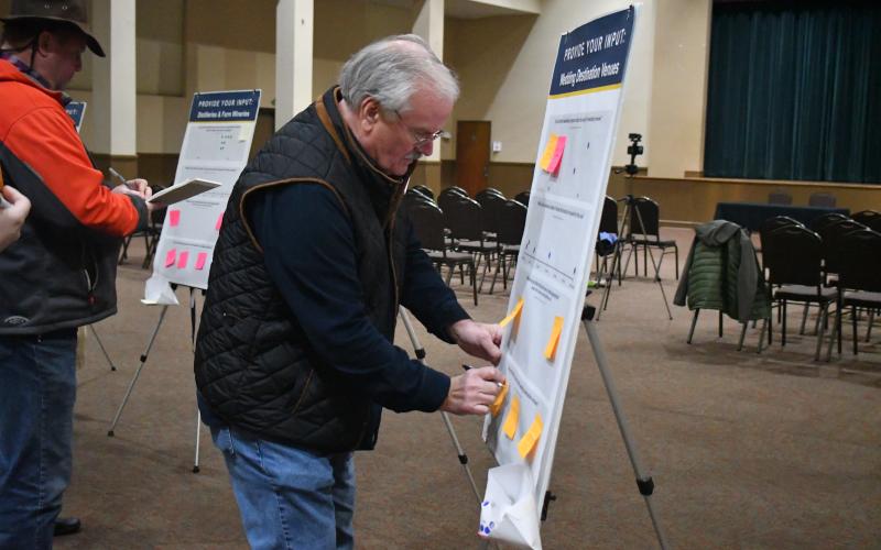 Megan Broome/The Clayton Tribune. Rabun County community member Lee Penland provides his opinion on what should happen with zoning in Rabun County by interacting at the open house Feb. 9 and publishing a sticky note on one of the bulletin boards with questions for consideration. The open house was organized to gauge input on the county’s zoning ordinances, specifically regarding non-traditional developments.