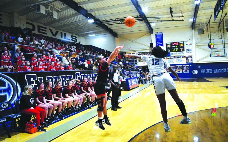 Luke Morey/The Clayton Tribune. RCHS junior Ellie Southards releases a three-point shot Tuesday evening on the road at Elbert County over Lady Blue Devils defender Brenasia Faust. The Lady Cats fell 52-41 in the region showdown.