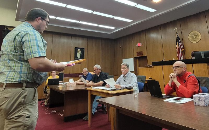 Megan Broome/The Clayton Tribune. Rabun County Zoning Administrator Shylan Wood speaks to commissioners during Tuesday’s work session about the zoning commission’s recommendation to approve with stipulations a rezoning request for 5 acres in Tiger from Agricultural (A) to Specific Purpose for the purpose of development of a covered storage facility. The vote by commissioners failed to pass due to lack of majority.