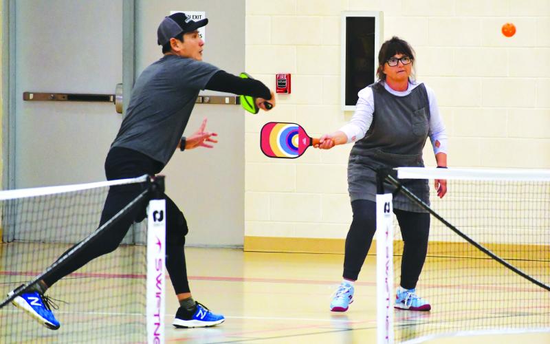 Photography by Tribune staff and Rabun County Recreation Department staff. Yong Kim returns a hit while Caroline Frick looks on at the annual Battle of the Paddles. Kim and Frick took the bronze medal for the mixed doubles 3.0 skill level from ages 14 to 59. Kim and Frick are a part of the Rabun County pickleball players who took home 10 gold medals from the Battle of the Paddles tournament that began Friday, March 17, and ended on Sunday, March 19.
