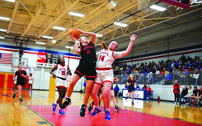 Luke Morey/The Clayton Tribune. Lucy Hood finishes through contact for the and-one in the waning seconds of the third quarter against Oglethorpe County. Oglethorpe County held onto a narrow lead to make it to the Elite Eight with a 51-50 victory.