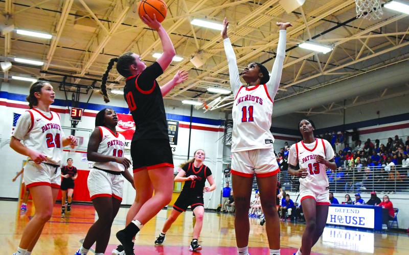 Luke Morey/The Clayton Tribune. RCHS junior Mili Watts, after losing her shoe on a rebound, scores on a floater over Oglethorpe’s Denim Goddard. Watts led the Lady Cats with 16 points in the Sweet Sixteen game.