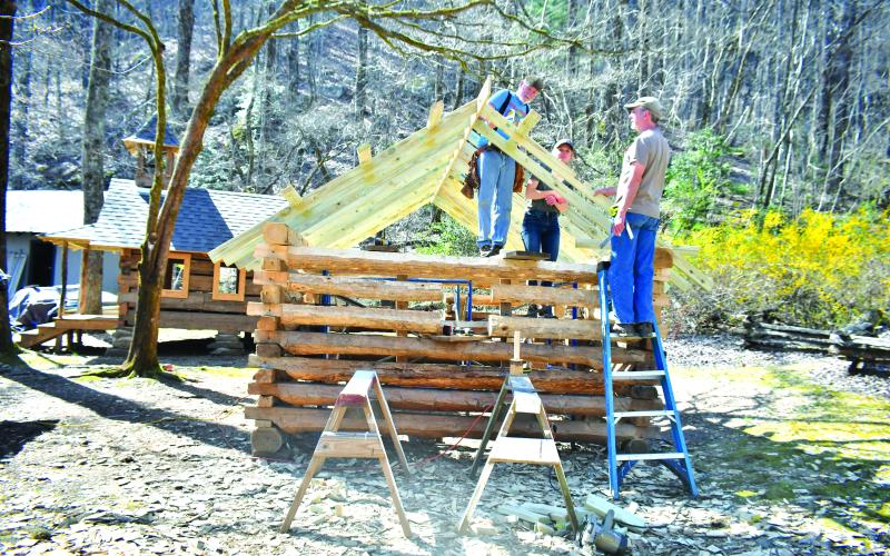 Megan Broome/The Clayton Tribune. Volunteer Tommy Thompson; Kami Ahrens, curator and director of education for Foxfire; and Barry Stiles, museum director, work to build the Ingram Mule Barn as the newest addition to the Children’s Village at the Foxfire Museum and Heritage Center. The scaled-down village for kids, modeled after existing buildings, is being built by hand using traditional tools like those used over 100 years ago.