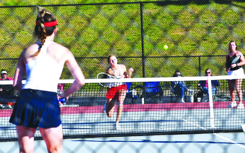 Luke Morey/The Clayton Tribune. RCHS senior Natalie Watson (left) returns a hit against Mt. Pisgah with teammate and fellow senior Allana Jones looking on. Watson and Jones, the No. 1 doubles duo, won against Mt. Pisgah but the Rabun County team fell 3-1 to bow out of the GHSA State playoffs in the Sweet Sixteen.
