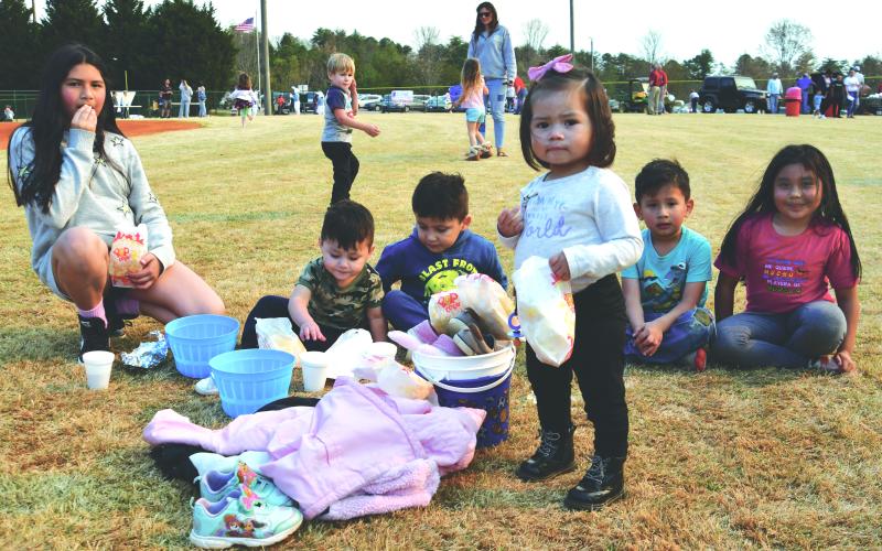 A group of children sits on the outfield grass at the Rabun County Recreation Department complex to eat some popcorn and await the start of the Easter egg hunts. From left are Joselyn Avredondo, Amir Correa, Zaid Correa, Adela Garcia, Andrew Garcia and Sarah Correa.