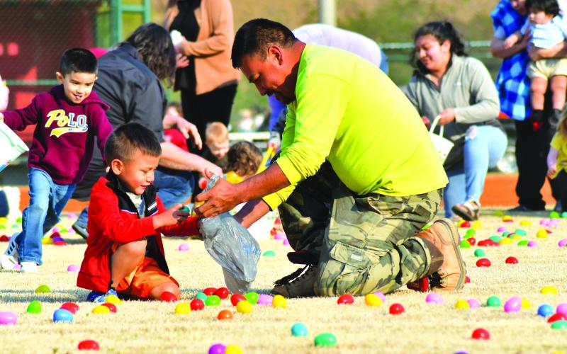 Ivan Monrou Sr. helps his 3-year-old son Ivan Monrou Jr. in collecting plastic Easter eggs at the annual Rabun County Recreation Department Easter Egg Hunt. The hunts were divided into three separate age divisions. Each egg had a prize inside and one  egg in the hunts on the ballfields had a slip of paper denoting a grand-prize winner of a new bicycle.