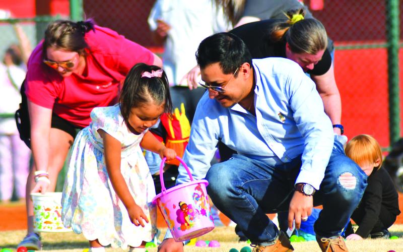 Daniel Contrevas helps his 3-year-old daughter Amalia during the Easter egg hunt.