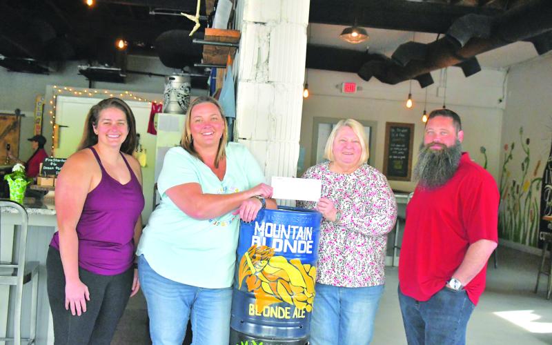 Megan Broome/The Clayton Tribune. Nancy Gribble with Ferst Readers of Rabun County accepts a donation check for $3,075 from nonprofit night held at Currahee Brewing Company on April 6. Pictured are Ara Joyce, Hillary Marshall, Gribble and Scott Mazarky.