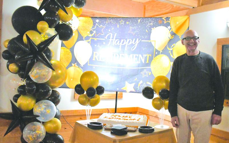 Megan Broome/The Clayton Tribune. Dr. Guy Gober of Tiger Clinic stands in front of his cake that reads “Happy Retirement!” during his retirement party Friday, March 31, after being in Rabun County for 33-and-a-half years.
